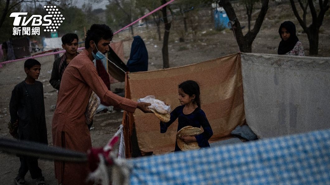 阿富汗人分發食物給國內難民無家可歸的難民。（圖／AP） 缺錢也缺糧！聯合國：百萬阿富汗兒童恐因營養不良死亡