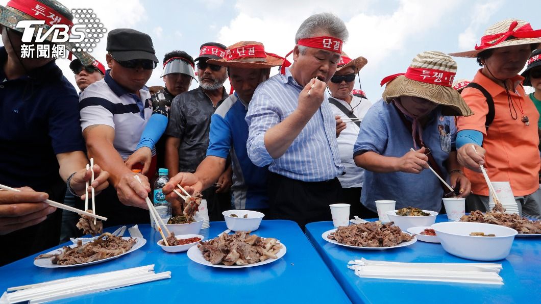 南韓挺食用狗肉人士在示威活動中大啖狗肉。（圖／達志影像美聯社）