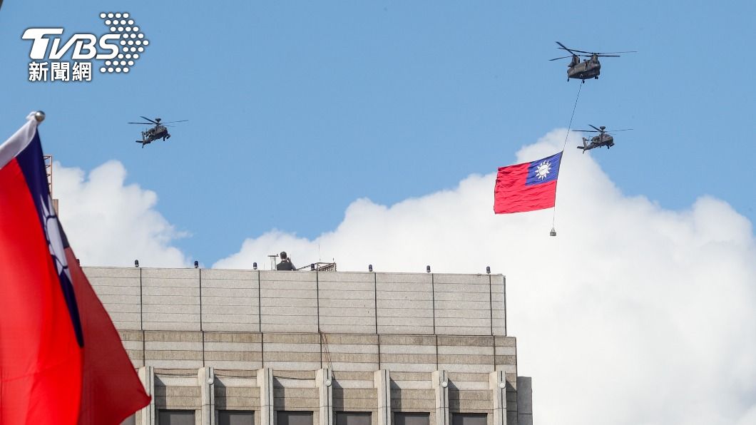 CH-47直升機吊掛巨幅國旗飛越總統府前廣場上空。（圖／中央社）