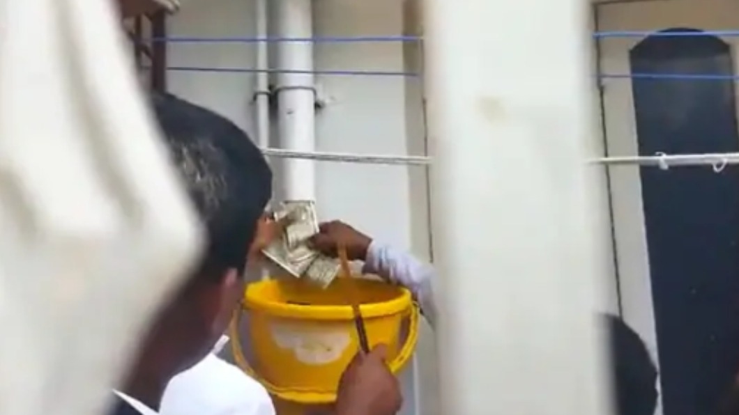 執法人員從排水管內拉出大量鈔票。（圖／翻攝自ANI 推特 @ANI）