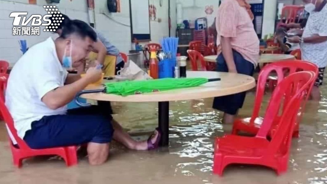馬來西亞台商拍下民眾雙腿泡在水裡用餐的畫面。（圖／TVBS）