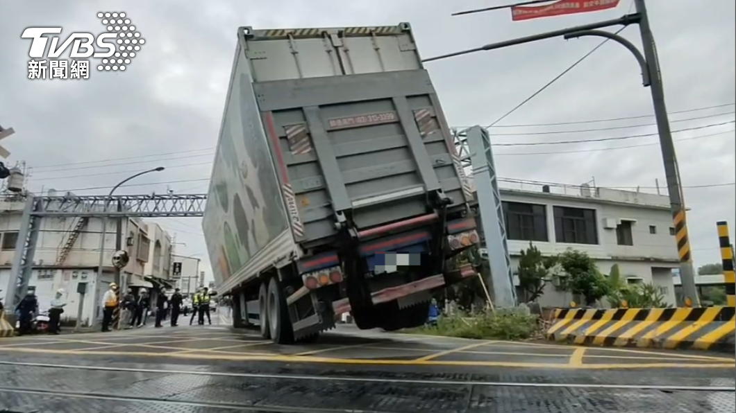 貨櫃車撞歪限高門，卡在平交道上。（圖／TVBS）