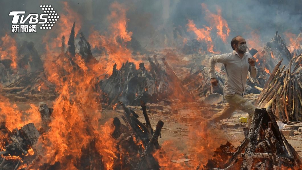 印度新德里近郊火葬場，一次火化大批新冠死者，火化高溫讓男子受不了，手刀飛奔逃離現場。（圖／達志影像美聯社）