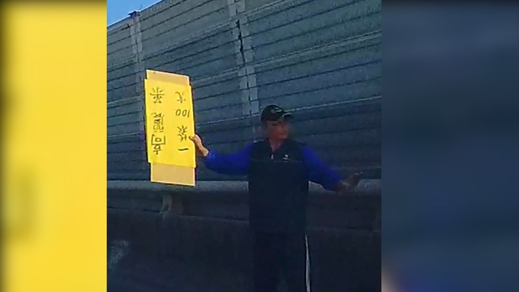 一名阿伯在國道路肩高舉黃色牌子。（圖／翻攝自爆廢公社臉書）