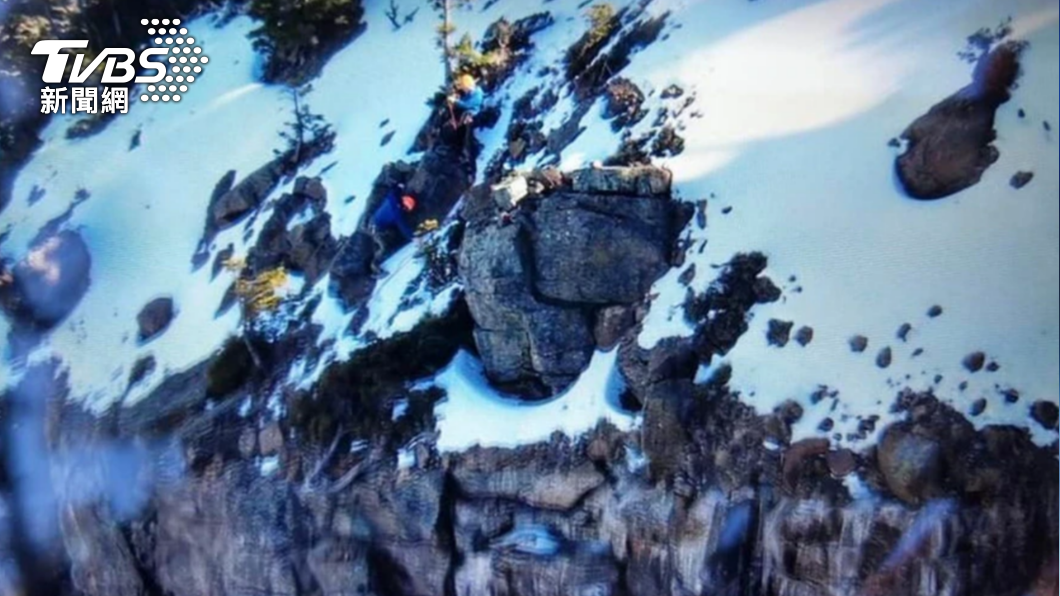 搜救人員攀爬近90度的山壁，將受困山友救出。（圖／新竹縣消防局提供）