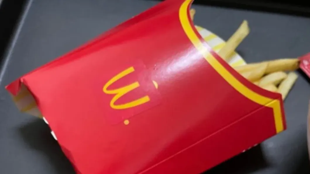 麥當勞薯條外盒貼著一張顛倒的Logo貼紙。（圖／翻攝自Dcard）