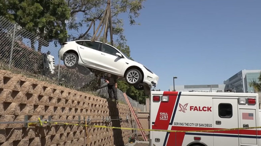 一輛Tesla Model 3飛下落差數公尺的牆壁，一頭撞上救護車。（圖／翻攝自Onscene.TV）