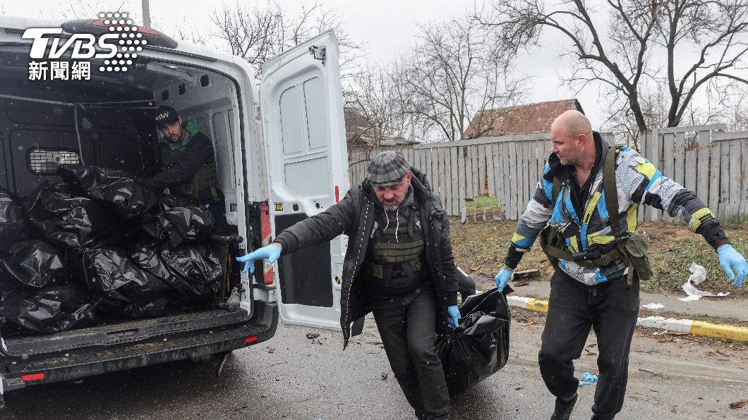 在烏克蘭基輔地區的布查，工作人員準備將平民的屍體放入一輛載有屍袋的貨車中。（圖／達志影像路透社）