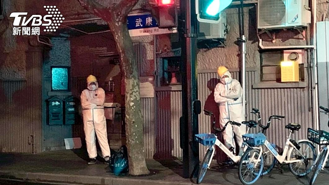 上海政府人員穿著防護衣站在街頭。（圖／達志影像美聯社）