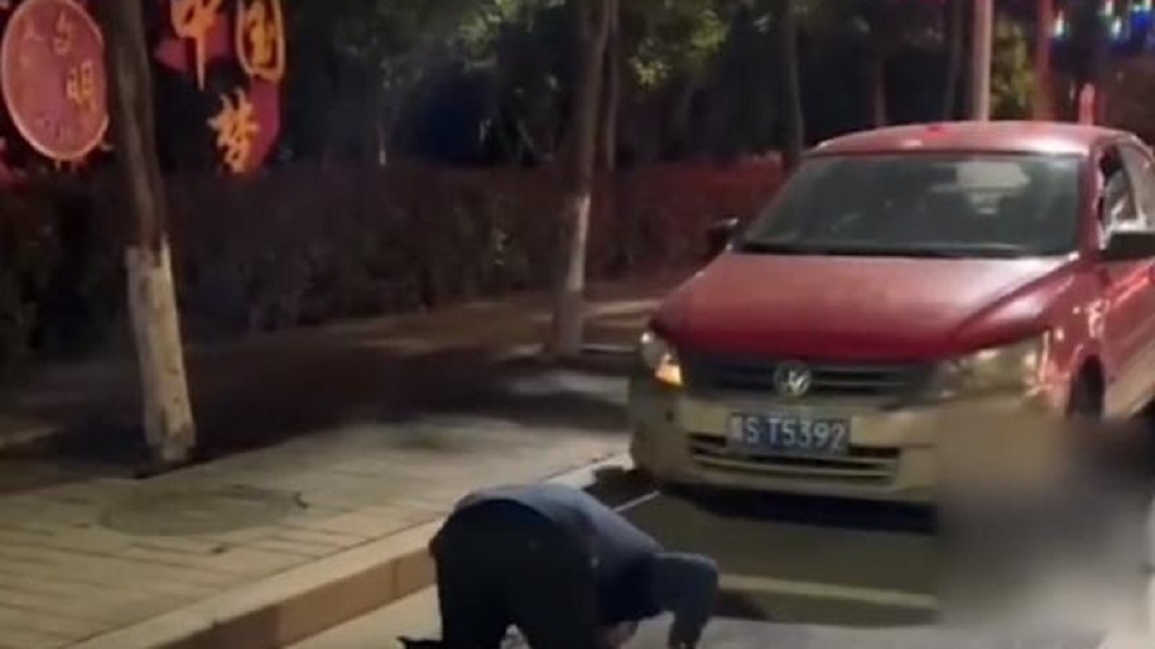河南一名男子日前突然對著車子下跪磕頭。（圖／翻攝自網易新聞）