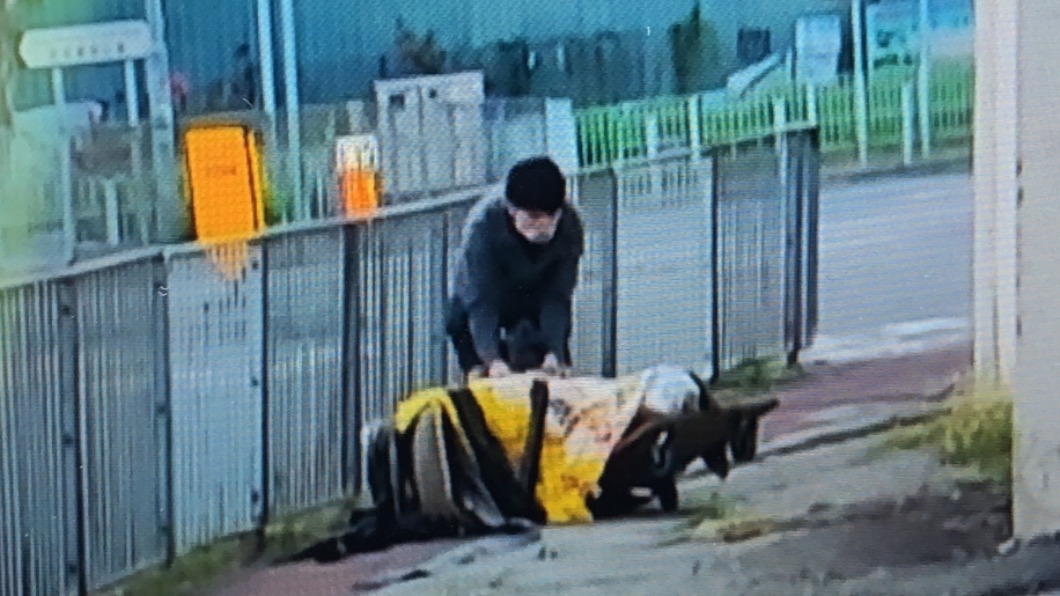 涉案男子拖着一具屍體。 （圖／翻攝自香港01）