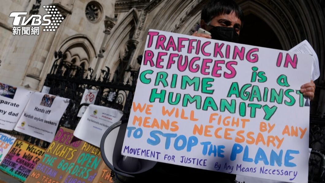 示威群眾手持標語，指控英國遣送難民的行為不人道。（圖／達志影像美聯社）