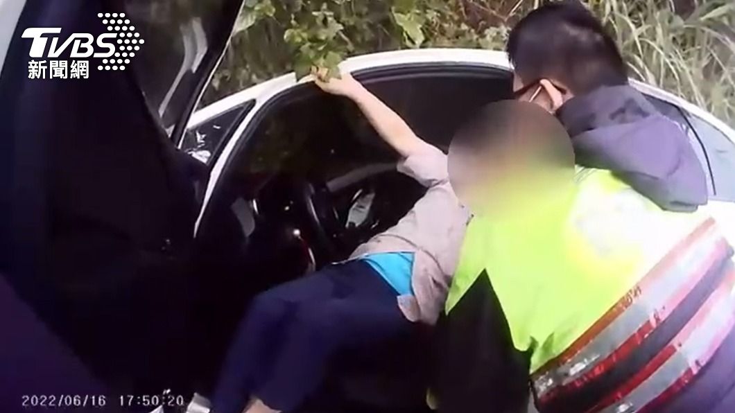警員將受困車內的黃男抱出車外。（圖／TVBS）