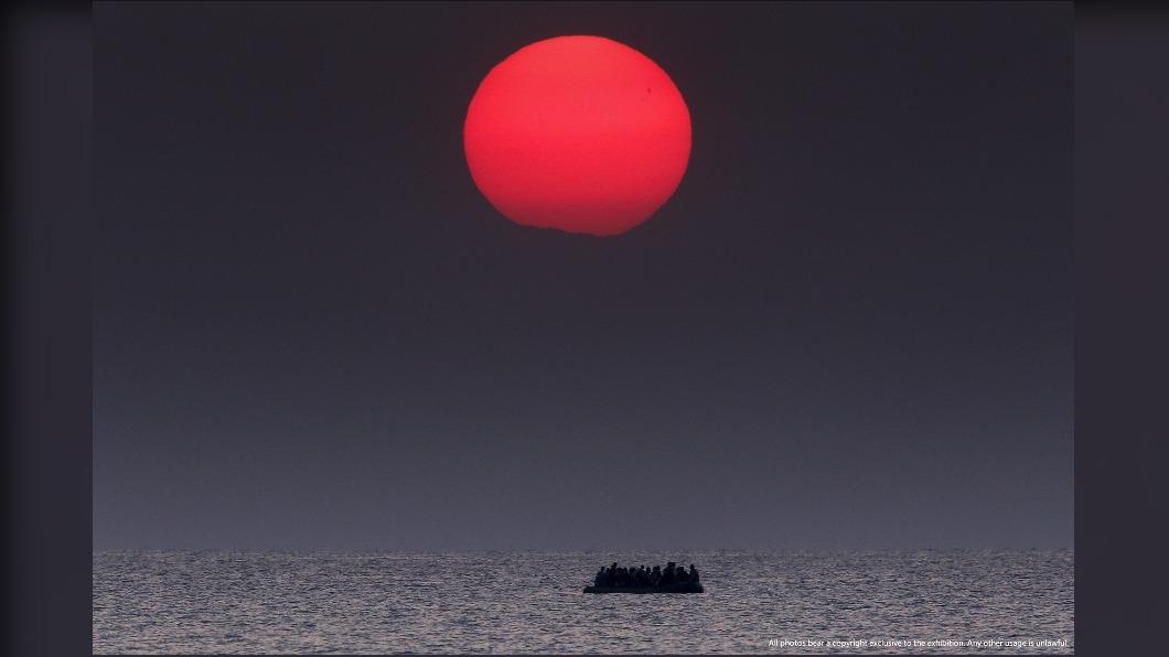 希臘攝影記者貝拉基斯拍下了豔陽與敘利亞難民同框的照片，充滿意象性的作品因此獲得普立茲攝影獎殊榮。（圖／普立茲新聞攝影獎80週年展））