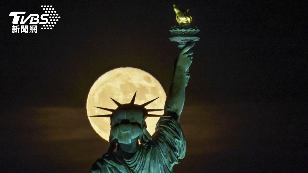 美麗的超級月亮陪伴紐約自由女神。（圖／達志影像美聯社）