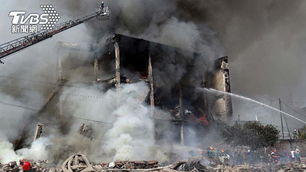 事故大樓被炸毀，消防人員急著滅火。（圖／達志影像美聯社）