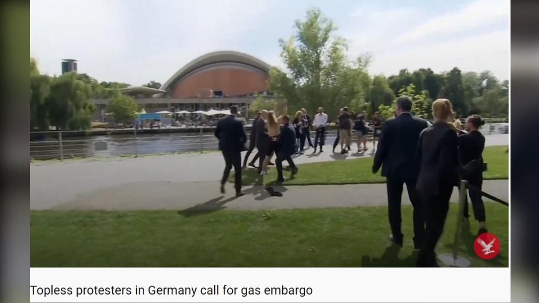 德國總理蕭茲在總理府因天然氣議題遭到抗議人士脫衣抗議。（圖／翻攝自The Independent YouTube）