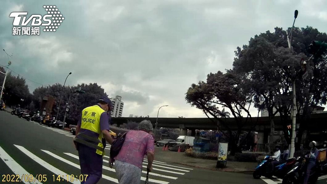 警員攙扶護送老婦人過馬路。（圖／TVBS）