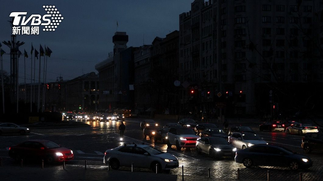 俄方攻擊讓烏克蘭首都基輔晚間陷入大停電，路燈都無法點亮，僅有汽車頭燈的燈光。（圖／達志影像路透社）