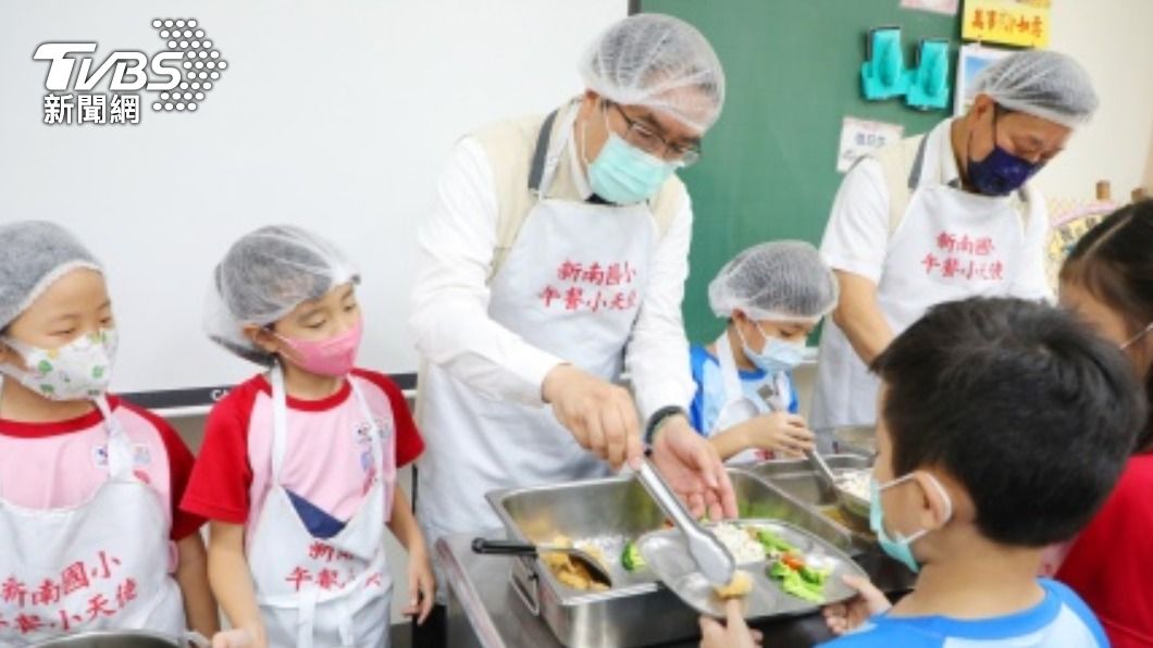 台南市長黃偉哲為學生打菜添飯。（圖／中央社）