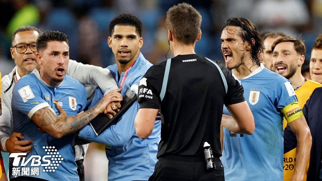 賽後一眾烏拉圭球員圍著裁判，抗議他沒給12碼罰球的判決。（圖／達志影像路透社）