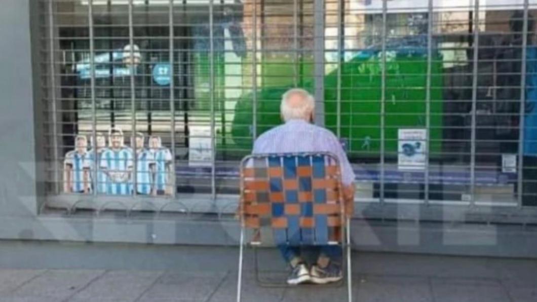 阿根廷老翁在街頭看球的照片，在網上瘋傳。（圖／翻攝自推特）