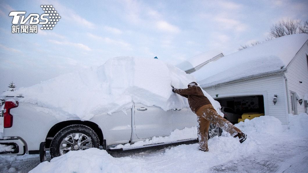 暴風雪襲捲全美各地，一民紐約市民正在清理他車輛上的積雪。（圖／達志影像路透社）