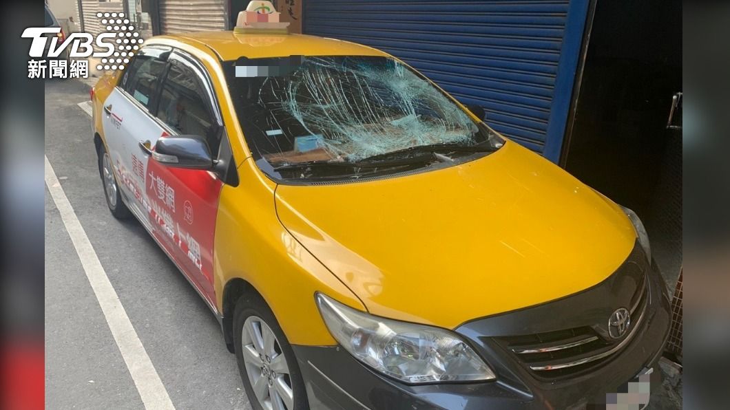 婦人墜樓摔在計程車上，導致擋風玻璃破裂。（圖／TVBS）