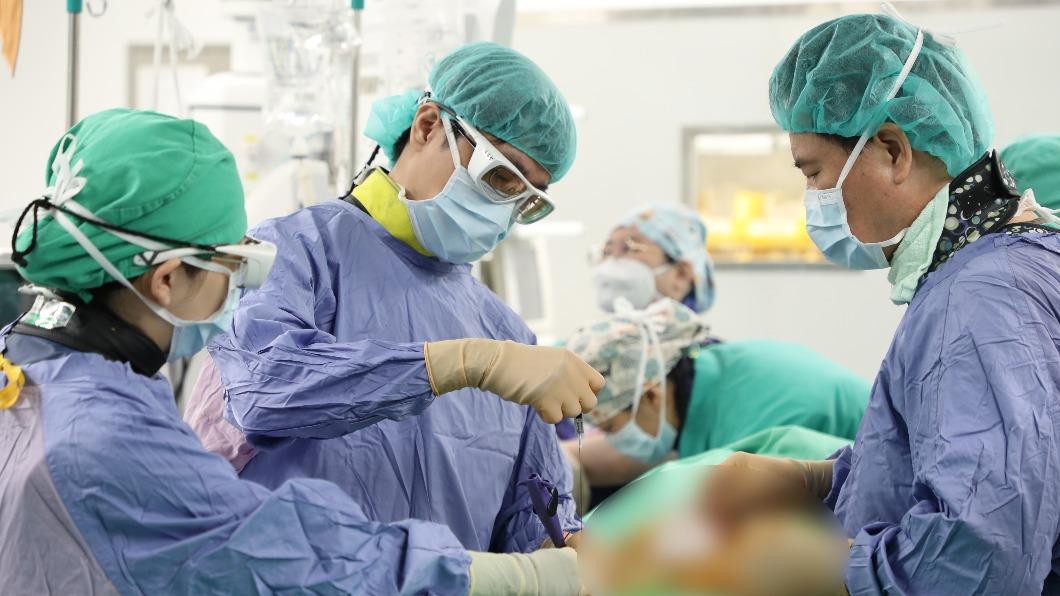 心臟外科張睿智主任於患者腿部動脈置放長管，並把金屬導絲穿進長管內。(圖/慈濟醫院提供)