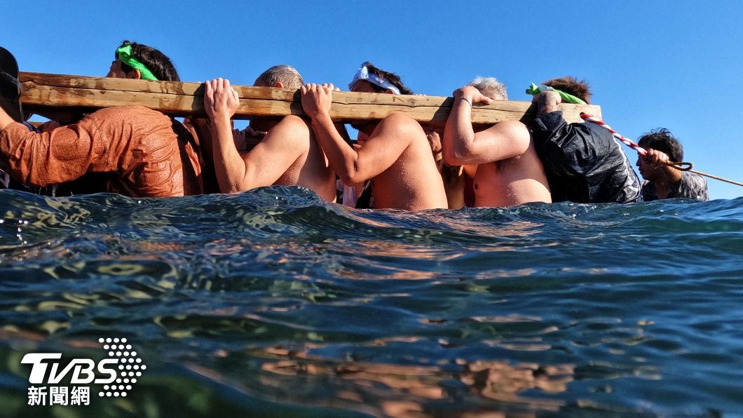 日本信徒頂著低溫，打赤膊扛著神輿船出海。（圖／達志影像路透社）