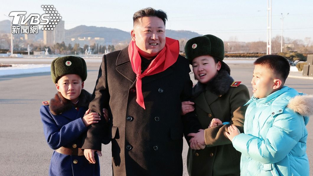 北韓領導人金正恩與朝鮮少年團孩童合影，但圖左孩童卻面露難色。（圖／達志影像路透社）