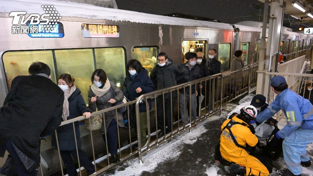 長時間被困在電車內，旅客們只能沿著鐵軌慢慢走進車站。（圖／達志影像美聯社）