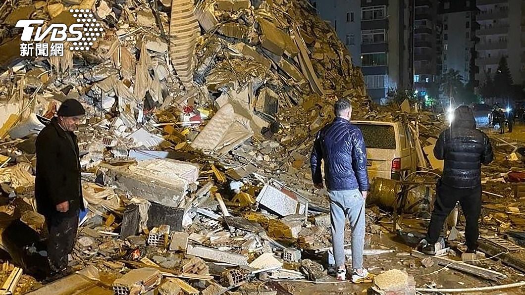 土耳其南部城市迪亞巴克爾（Diyarbakir）的民眾站在被摧毀的建築物旁。（圖／達志影像美聯社）