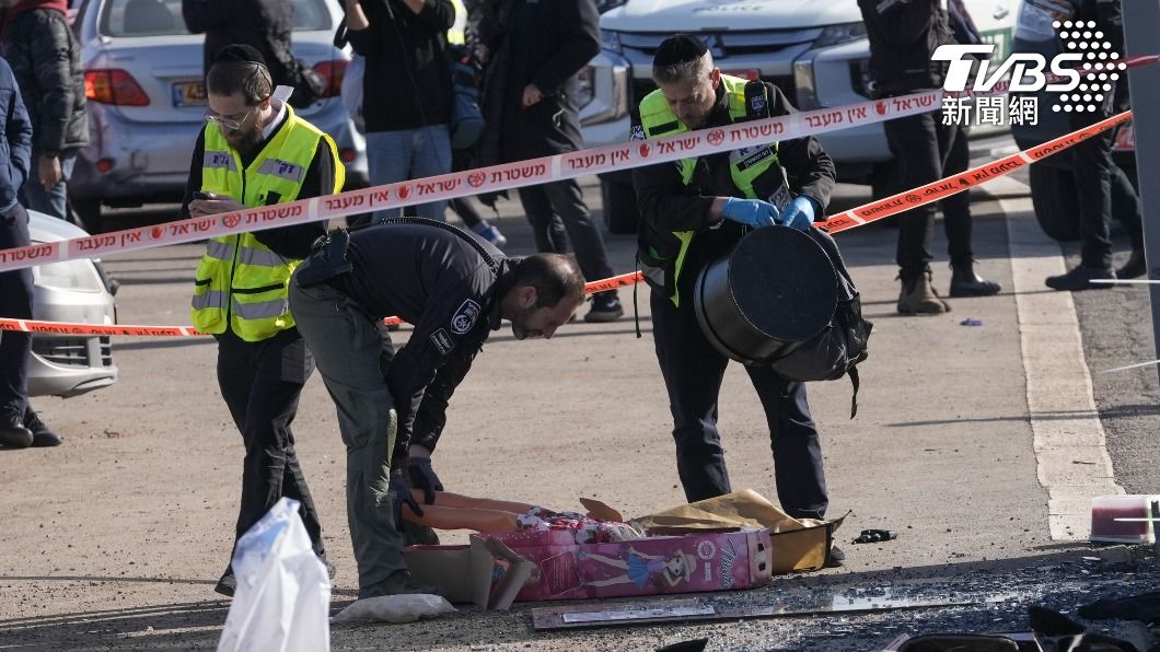 民間組織ZAKA成員與以色列警方撿起汽車衝撞攻擊事件掉落的娃娃。（圖／達志影像美聯社）
