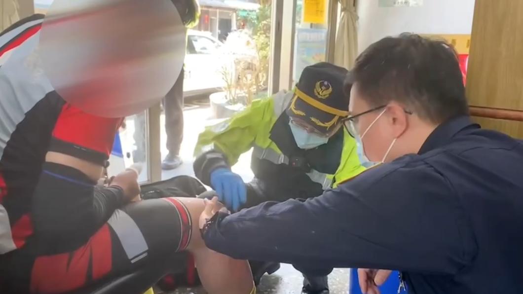 在派出所內的日籍男子高橋，消防隊員以及警察，正在幫他包紮傷口止血　（圖／瑞芳分局提供）