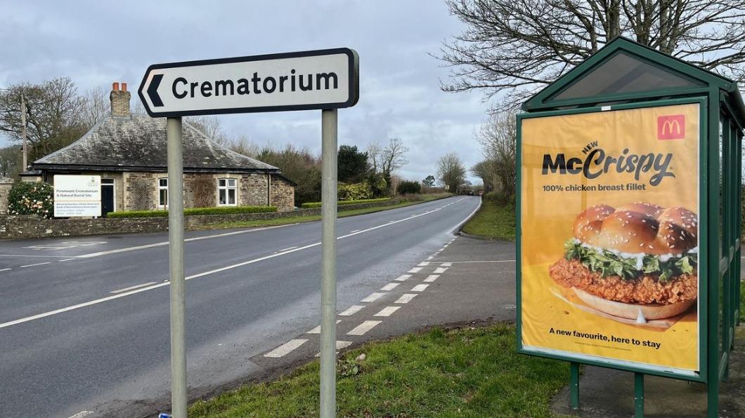 麥當勞廣告恰好立在火葬場的路標旁邊。（圖／翻攝自Cornwall Live）