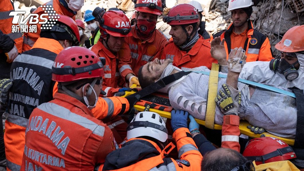 救難人員小心翼翼的將男子安置在擔架上，從廢墟中抬出。（圖／達志影像美聯社）