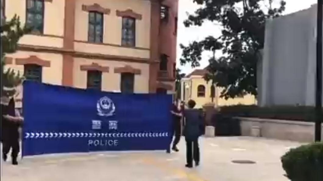中國公安兩人一組手持巨幅藍色布幕，遮住示威者後進行逮捕。（圖／翻攝自推特）