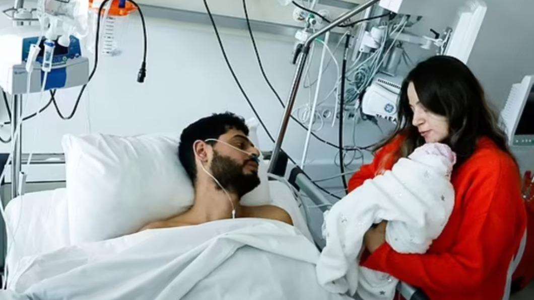 33歲土耳其男子阿夫奇（Mustafa Avci）獲救後，在病房內首次見到剛出生的愛女。（圖／翻攝自《每日郵報》）