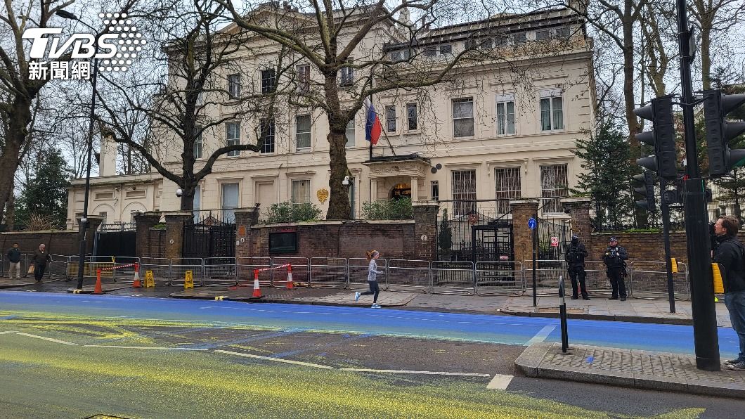 俄羅斯駐英國大使館遭政治行動藝術團體潑漆，瞬間變成烏克蘭國旗。（圖／中央社）
