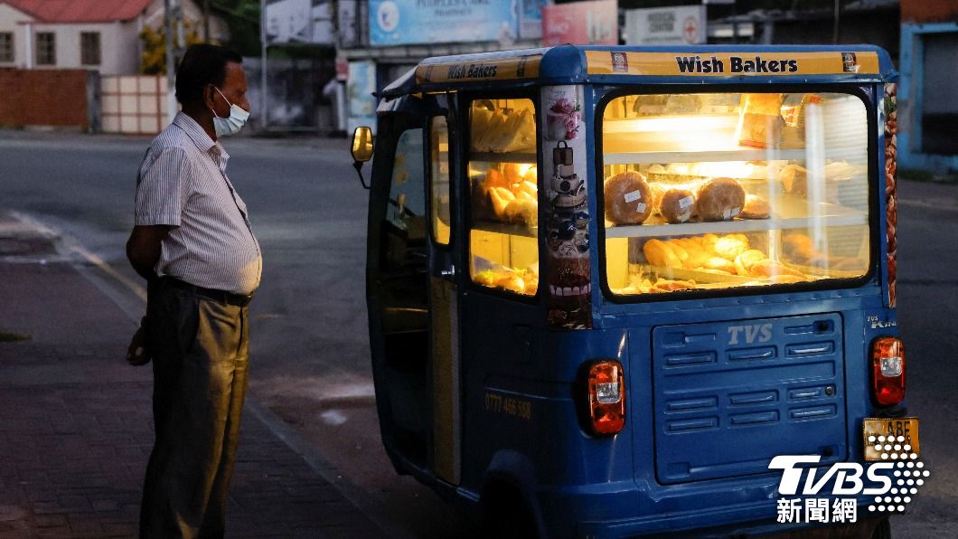 斯里蘭卡一位男子站在裝滿麵包的車旁，上頭寫著的「希望麵包」字樣，似乎也說著全斯里蘭卡民眾的冀望。（圖／達志影像路透社）