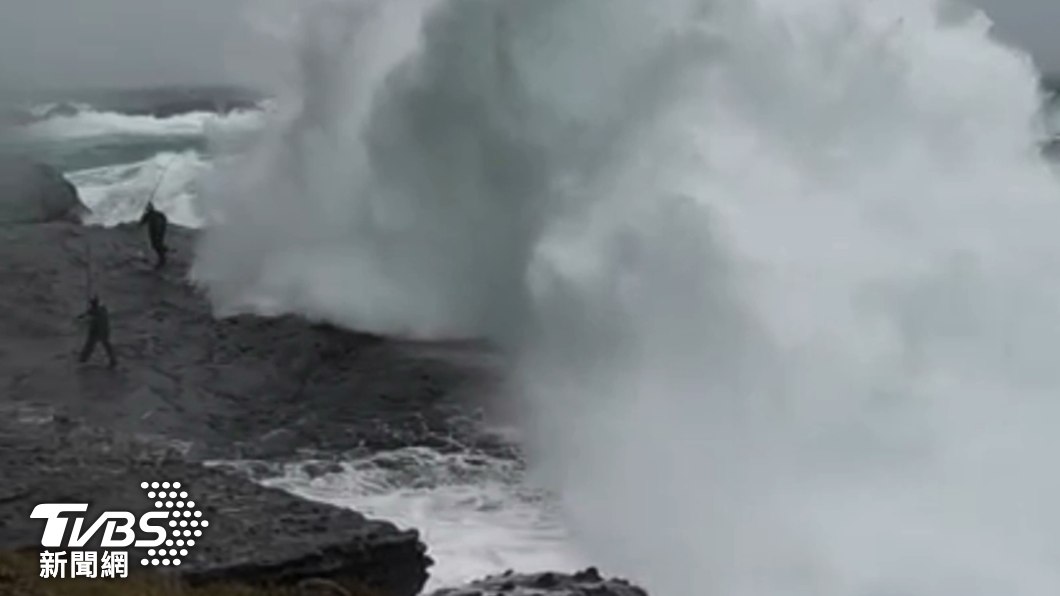 高十多公尺的大浪來襲，兩名釣客反應不及，立刻被大浪吞噬，還好沒被捲入海裡　（圖／ＴＶＢＳ）