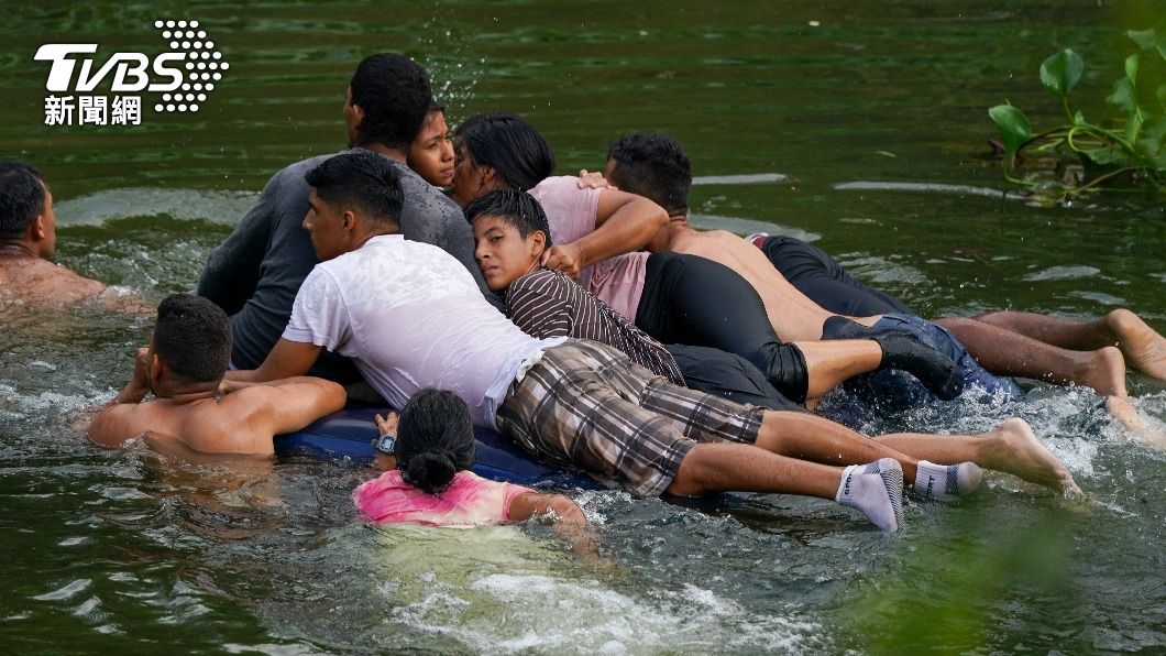 9位移民擠在一張充氣床墊渡河。（圖／達志影像美聯社）