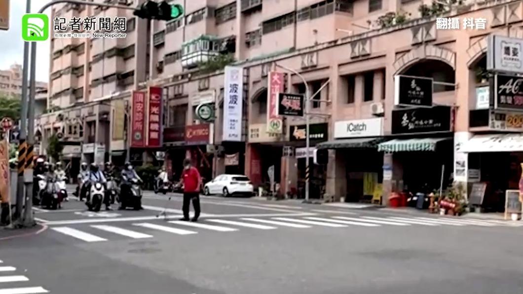 一排機車騎士耐心地等待老翁過馬路。（圖／翻攝記者新聞網）