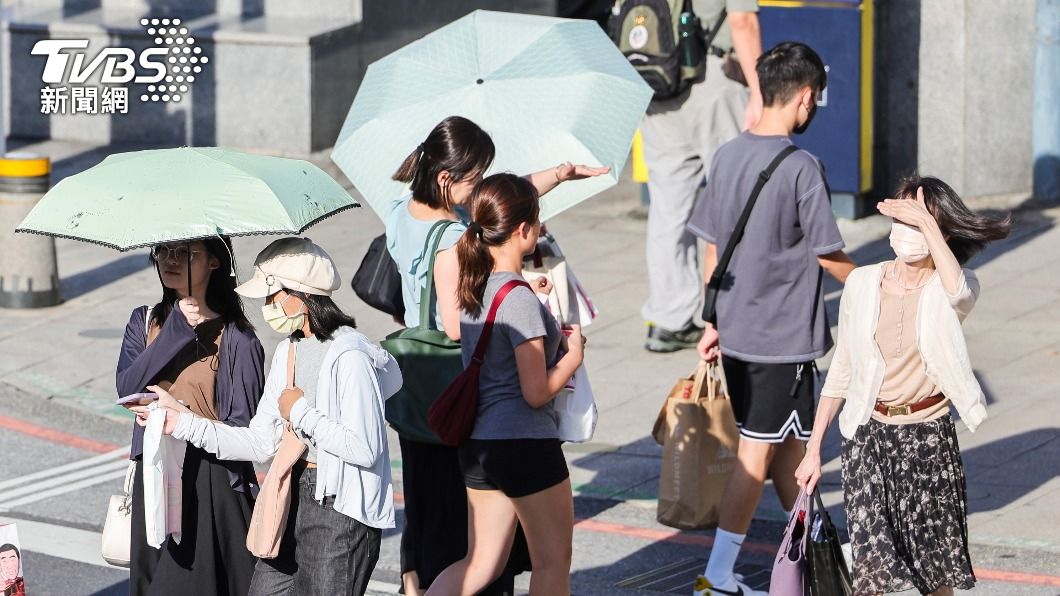 民眾撐傘走在台北市萬華區街頭。（圖／中央社）
