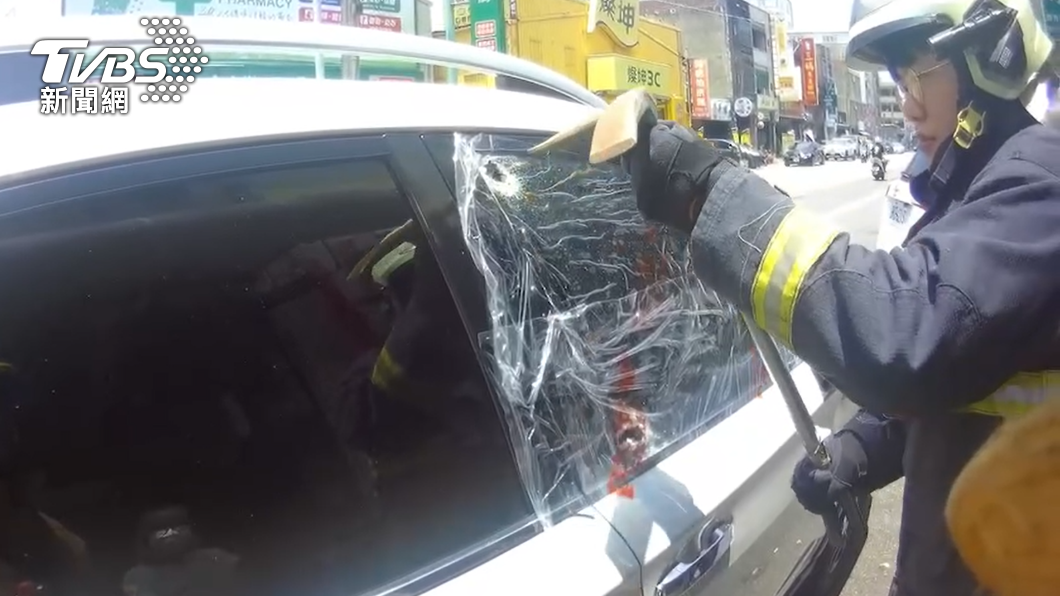 消防人員小心敲破車窗。（圖／TVBS）