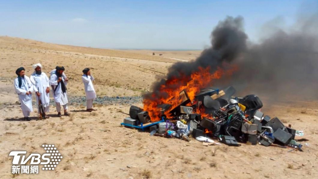 阿富汗塔利班官員蒐集大量樂器，公開在鏡頭前進行焚燒。（圖／達志影像歐新社）