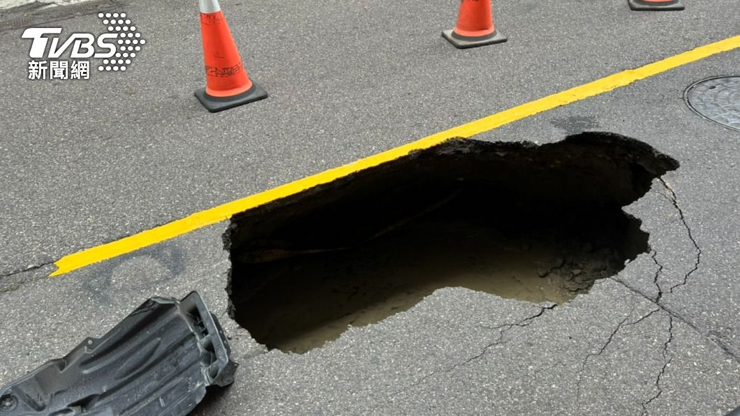 臺南市安平區道路出現深約1米的坑洞，一輛行徑的小客車慘遭波及。（圖／TVBS）