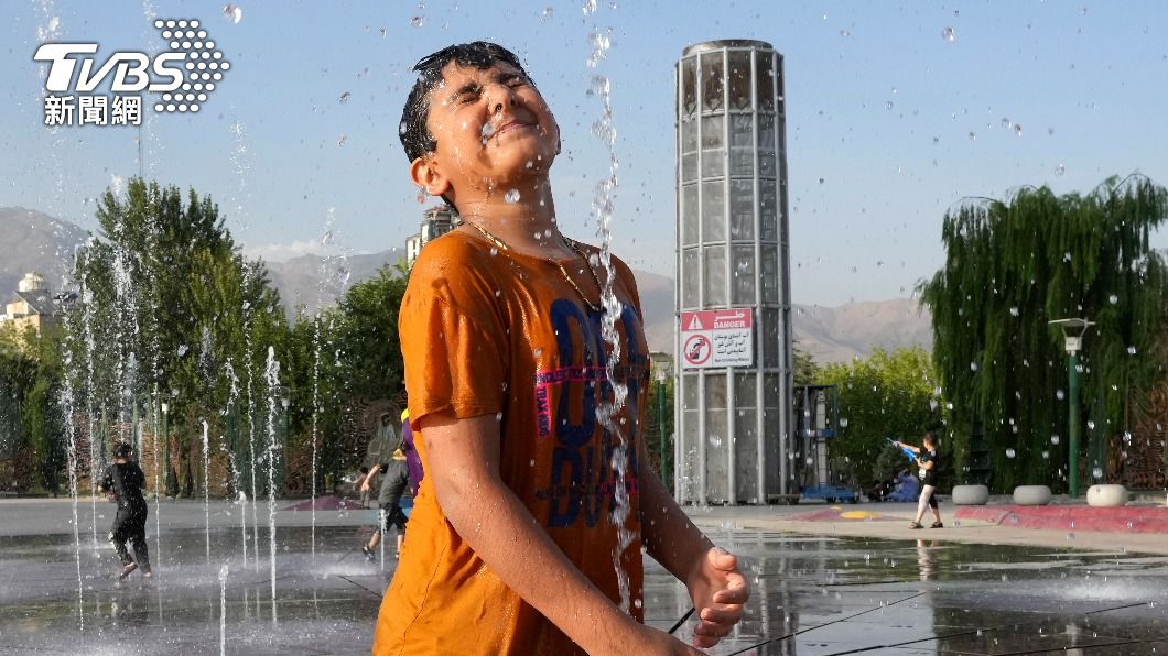 伊朗首都德黑蘭1日高溫達到攝氏37度。炎熱天氣下，市民在噴水設施旁玩水消暑。（圖／達志影像美聯社）