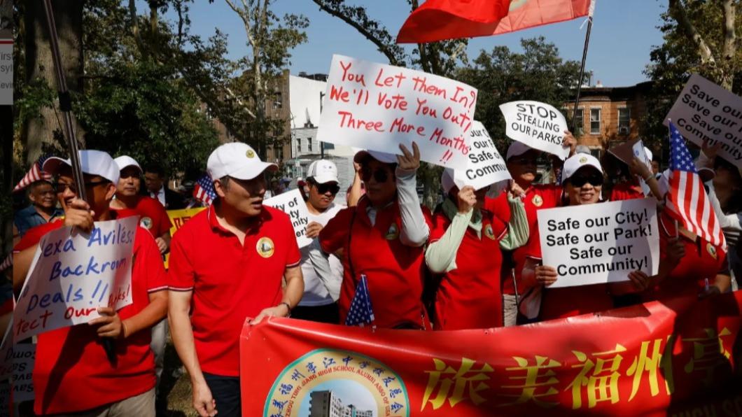 超過300位中國移民走上街頭，抗議紐約市政府強行「棄置」近百名難民。照片中一位居民手舉標語寫著：「你（政府）讓難民進來，我們就用選票讓你滾出去！」（圖／翻攝自「紐約郵報」）